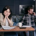 woman in white long sleeve shirt sitting beside man in black and white checkered dress shirt